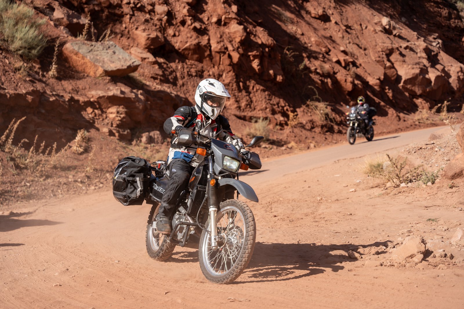 Riders sur une route de canyon aux roches rouges au Maroc