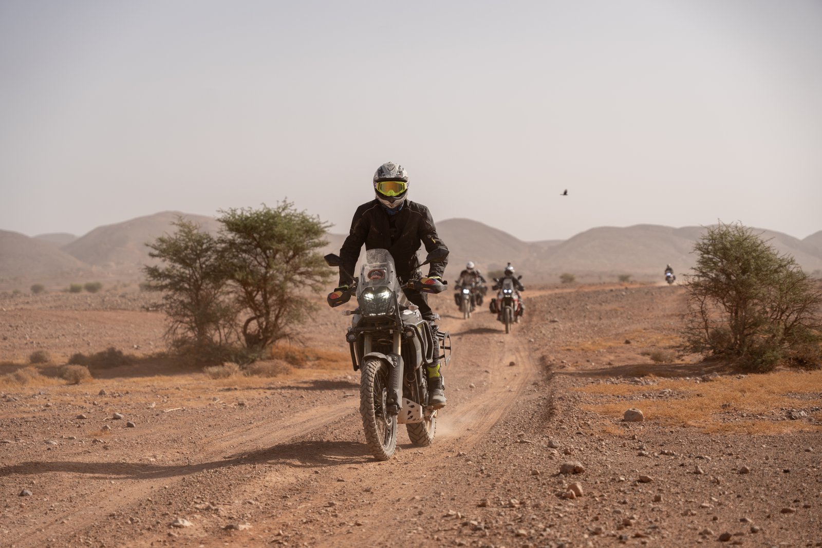 Moto roulant sur une piste poussiéreuse de montagne au Maroc